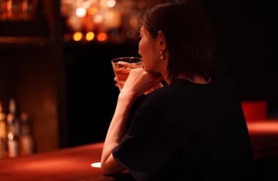 Femme dégustant un verre de rhum.